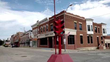 Antique-four-way-stop-light-and-buildings-in-downtown-Toledo,-Iowa-with-stable-video-close-up-at-an-angle
