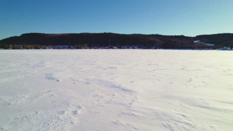 Drone-Volando-Sobre-Un-Lago-Congelado-En-Canadá-Siguiendo-Una-Moto-De-Nieve