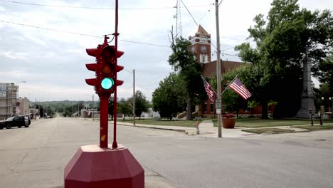 Antique-four-way-stop-light-and-courthouse-in-downtown-Toledo,-Iowa-with-stable-video