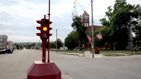Antique-four-way-stop-light-and-courthouse-in-downtown-Toledo,-Iowa-with-stable-video-close-up
