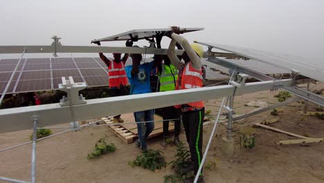 Professionelle-Ingenieure-Arbeiten-Als-Team-In-Afrika-Und-Installieren-Bifaziale-Solarmodule-In-Einer-Photovoltaikfarm-In-Der-Wildnis