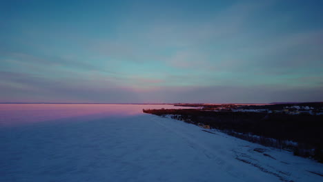 Flying-drone-above-a-frozen-lake-in-canada-at-golden-hour