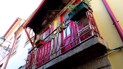 Einzigartiger-Blick-Auf-Eine-Winzige-Straße-Von-Porto-Mit-Leuchtend-Roten-Türen-Auf-Einem-Balkon,-Nach-Links-Geschwenkt