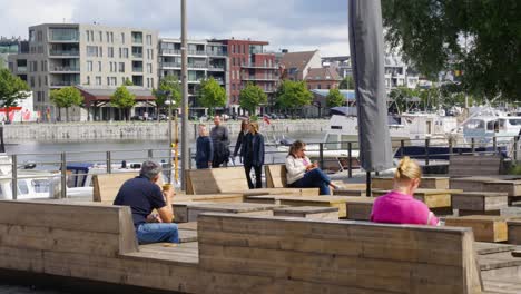 People-relaxing-on-benches-at-the-popular-quarter-'Het-Eilandje'-in-Antwerp,-Belgium---Slow-motion