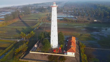 Lighthouse-overlooking-seasalt-ponds-at-ketawang-beach,-Indonesia