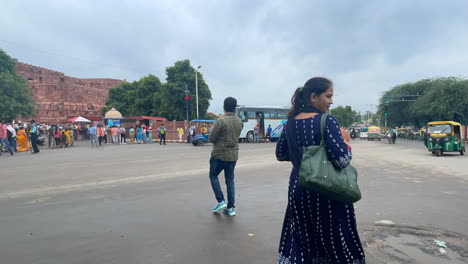 Gente-Caminando-Por-Las-Calles-De-La-Vieja-Delhi-Con-El-Fuerte-Rojo-Al-Fondo,-India--Timelapse