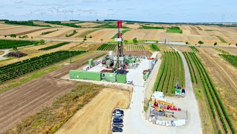 Oil-Rig-Drilling-Amongst-Agricultural-Fields-In-Austria---aerial-drone-shot