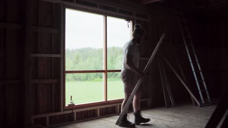 Man-Installed-Window-Sill-Inside-Wooden-House.-wide