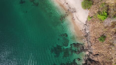 4K-Drone-Birdseye-Rotation-Above-Blue-Ocean-Water-With-Sandy-Beach-In-Costa-Rica