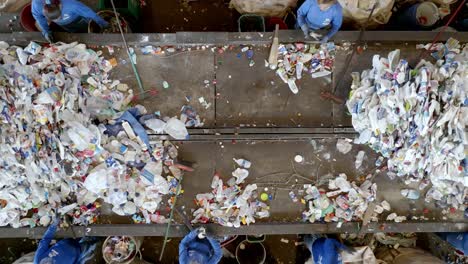 Vogelperspektive-Auf-Mitarbeiter,-Die-In-Einer-Recyclinganlage-Plastikmüll-Trennen
