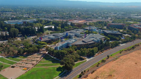 Aerial-view-circling-above-Google-Googleplex-headquarters-campus-buildings,-Silicon-Valley,-California