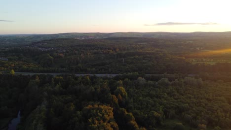 Luftaufnahmen-Am-Frühen-Morgen-über-Einem-Wald-Mit-Autos-Auf-Der-Autobahn-Und-Sonnenaufgang