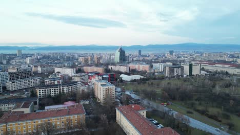 -Bulgaria-skyline-buildings-and-cityscape-at-sunset-under-hazy-sky-due-to-climate-change,-Drone-shot