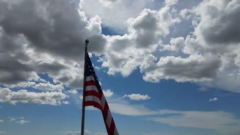 Amerikanische-Flagge-Weht-Im-Wind-An-Einem-Schönen-Sonnigen-Sommertag-Mit-Wolken-Und-Blauem-Himmel-Mit-Blick-Auf-Die-Berge-In-4K-60fps