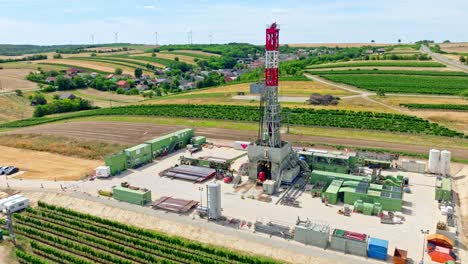 Oil-Rig-Drilling-On-Agricultural-Land-In-Austria---aerial-drone-shot