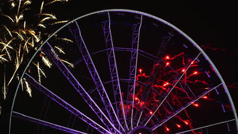 Fireworks-behind-the-illuminated-Centennial-Wheel-at-the-Navy-Pier,-night-in-Chicago,-USA