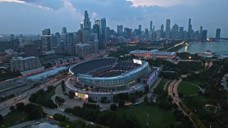Drone-shot-orbiting-the-Soldier-field-stadium,-cloudy,-blue-hour-in-Chicago,-USA