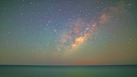 Timelapse-Unveils-a-Gentle-Green-Starry-Sky-as-it-Glides-Across-the-Ocean-Horizon