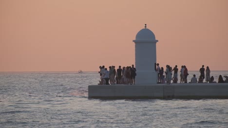 People-watching-sunset-and-kids-jumping-in-the-Adriatic-with-boats-passing