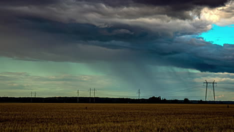 Rain-and-storm-clouds-gather-and-spread-across-open-farmland-field,-dark-grey-moody,-time-lapse