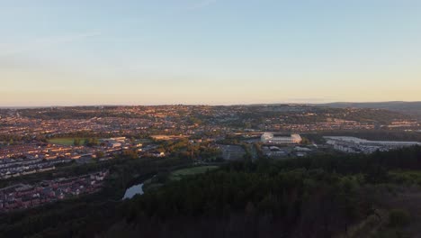 Pine-Forest-with-City-Houses-Stadium-and-Shopping-Center---Aerial-Drone-Sunrise