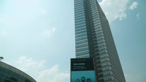 Asem-Tower-With-A-Huge-Advertisement-Display-And-Golden-Hands-Statue-At-Coex-Business-Complex-In-Seoul,-South-Korea