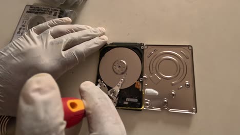 Computer-technician-repairing-internal-hard-drive-in-dark-room-and-storing-deleted-data