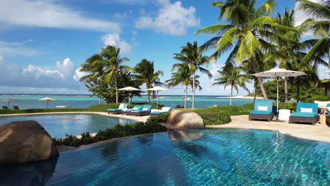 Luxury-Tropical-Resort,-Flying-Above-Swimming-Pools-With-View-of-Exotic-Landscape-and-Caribbean-Sea,-Drone-Shot