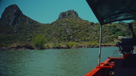 Looking-out-at-limestone-hills-from-a-boat-sailing-down-a-river-in-a-national-park-in-Thailand