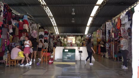 Slow-motion-shot-of-tourists-exploring-the-clothes-for-sale-at-a-large-mexican-market
