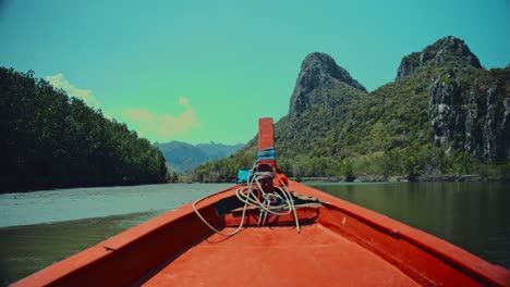 Sailing-down-a-river-in-Thailand-surrounded-by-limestone-hills