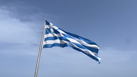 Bandera-Griega-Cinematográfica-En-Ondas-Polares-En-El-Viento,-Cámara-Lenta,-Cielo-Azul,-Nubes