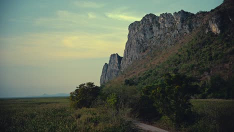 Limestone-hills-next-to-a-marsh-with-a-road-in-between-in-a-national-park-in-Thailand