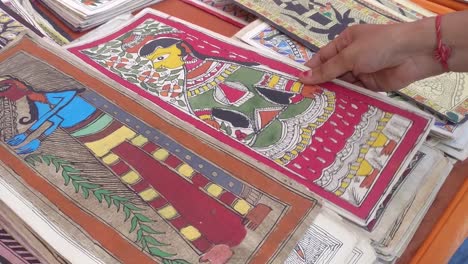 close-up-scene-showing-a-woman's-art-collection-of-amazing-and-ancient-Madhubani-paintings