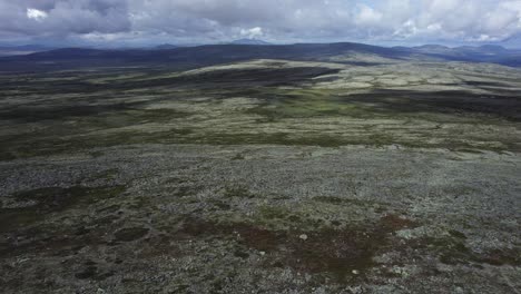 Aerial-descends-to-barren-rocky,-hilly-landscape-in-Spekdalen-Norway