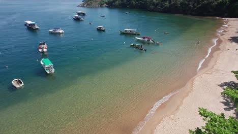 Aerial-descent-to-small-Brazilian-ocean-beach-lined-with-small-boats