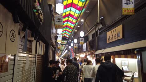 Touristen-Gehen-In-Die-Traditionellen-Geschäfte-Des-Nishiki-Marktes-In-Der-Innengalerie-Von-Kyoto,-Japan