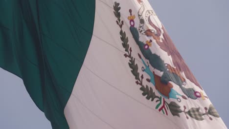 Mexiko-Flagge-Vor-Blauem-Himmel-Beim-Aufwachen-An-Einem-Windigen-Tag,-Zeitlupenansicht