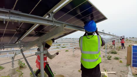 Workers-Installing-Bifacial-Photovoltaic-Panels-Over-Steel-Frame-Structures-At-The-Solar-Farm-Project-In-Jambur,-Gambia,-West-Africa