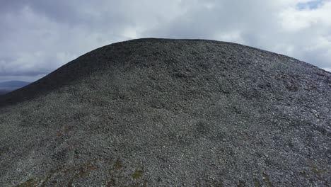 Norway-aerial-climbs-talus-slope-of-high-barren-hill-of-shattered-rock