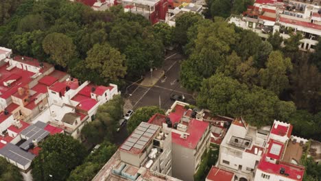 Street-traffic-and-red-rooftops-of-Mexico-city-suburbs,-aerial-view