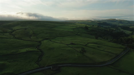 Drohnenaufnahme-über-Den-Feldern-Und-Hügeln-Von-Yorkshire-Dales-Mit-Niedrigen-Wolken