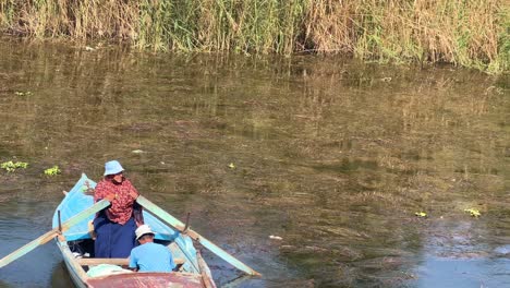 People-on-boat-on-the-Nile-River-close-to-Cairo-in-Egypt-during-the-day-with-fauna-and-vegetation-in-the-North-of-Africa