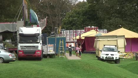Vehicles-belonging-to-the-funfair-parked-up-before-setting-up-the-fairground-attractions-in-the-town-park-during-the-school-holidays
