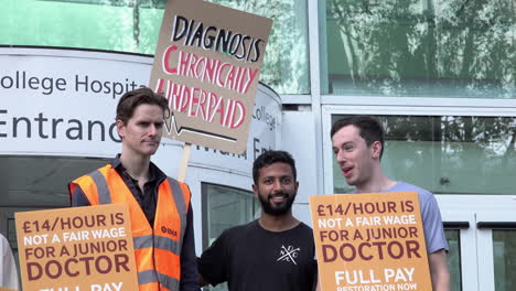 Striking-Junior-Doctors-stand-on-a-picket-line-outside-the-University-College-Hospital-hold-placards,-one-reads,-“Diagnosis-chronically-underpaid”