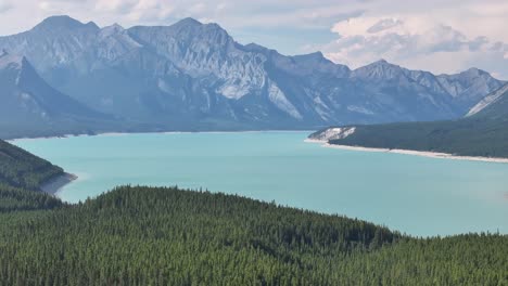 A-drone-rises-up-from-the-forest-to-reveal-the-eastward-view-of-Abraham-Lake-in-the-Rocky-Mountains-of-Alberta,-Canada