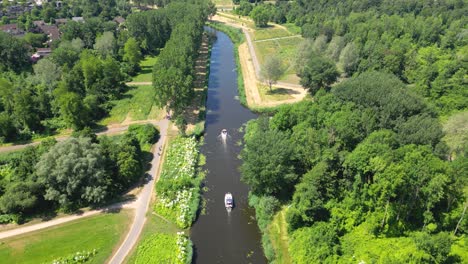 Aerial-drone-shot-above-a-nature-park,-water-canal-with-boats,-of-Almere-city,-province-Flevoland,-Netherlands