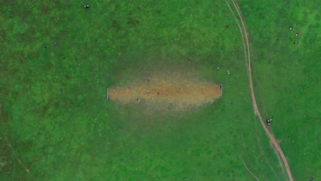 4k-aerial-bird's-eye-drone-shot-kids-playing-football-on-green-field