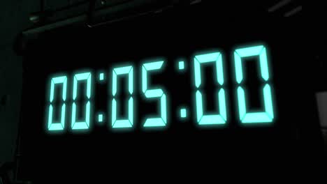 High-quality-CGI-render-of-a-digital-countdown-timer-on-a-wall-mounted-screen,-with-glowing-pale-blue-numbers,-counting-down-from-10-to-zero,-with-dramatic-right-to-left-camera-move