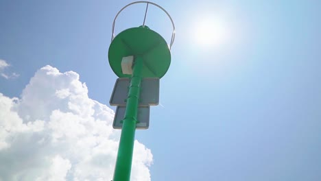 Atemberaubende-HD-Aufnahmen-Eines-Grünen-Leuchtturms-Im-Yachthafen-Von-Koper,-Beleuchtet-Von-Der-Sonne